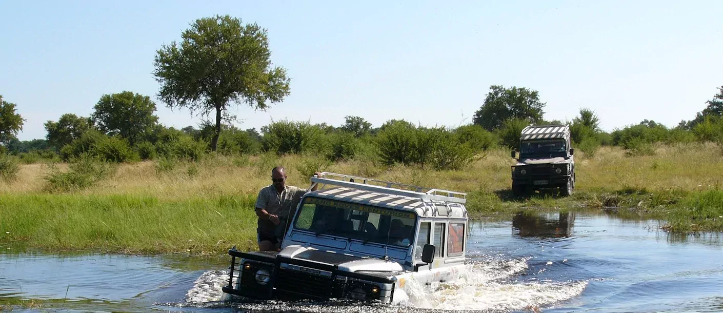 okavango delta - jeeps in rivier.webp